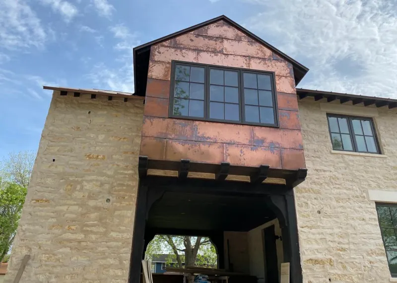 Copper metal panel facade on a stone building for Roof Repair in Northlake